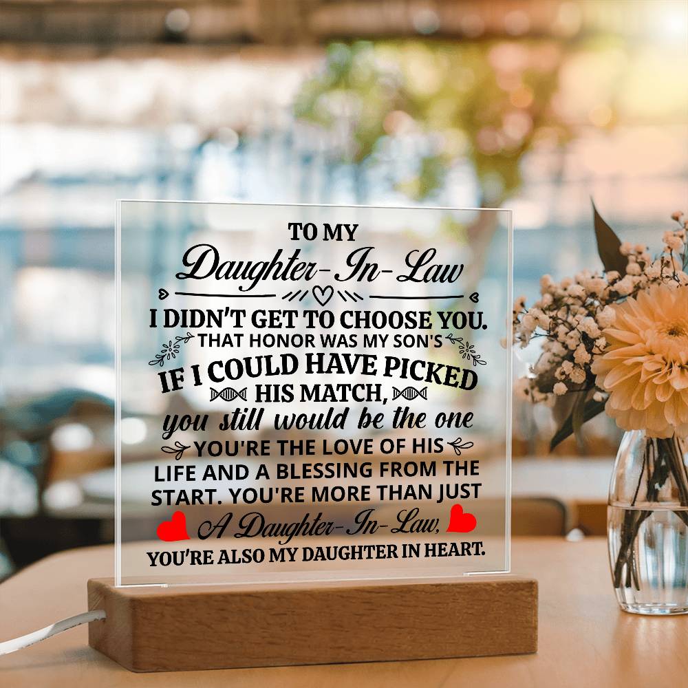 acrylic plaque for daughter-in-law displayed on wooden base with heartfelt message and flowers in background