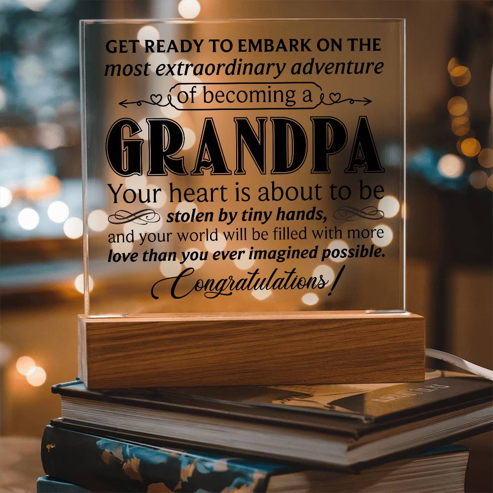 Acrylic square plaque celebrating the adventure of becoming a grandpa, displayed on a wooden base.