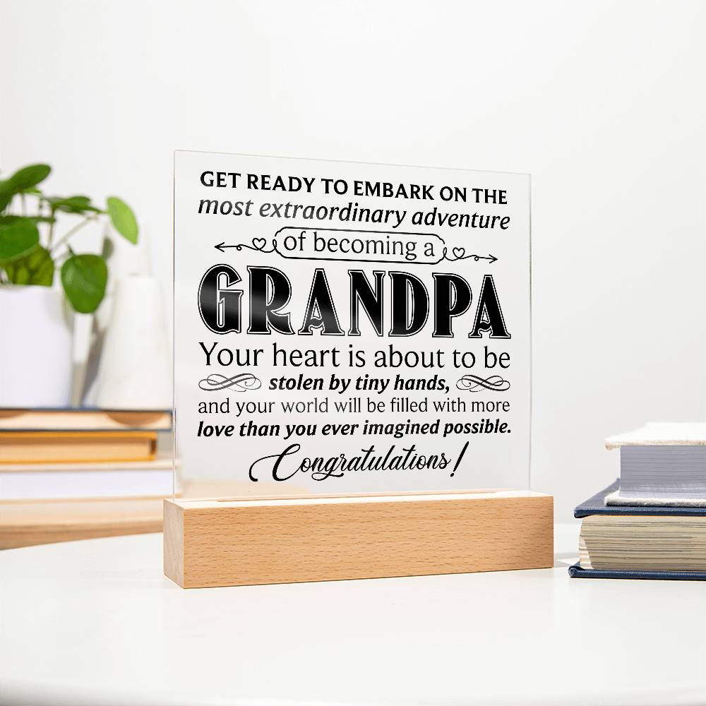 Acrylic square plaque celebrating becoming a grandpa, displayed on a wooden base with heartfelt message.