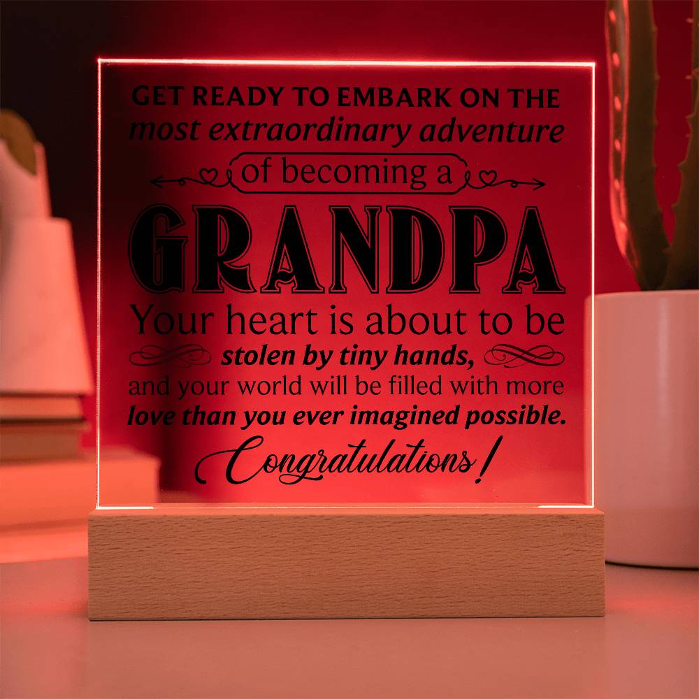 Acrylic square plaque displaying a heartfelt message about becoming a grandpa, showcased on a wooden base.