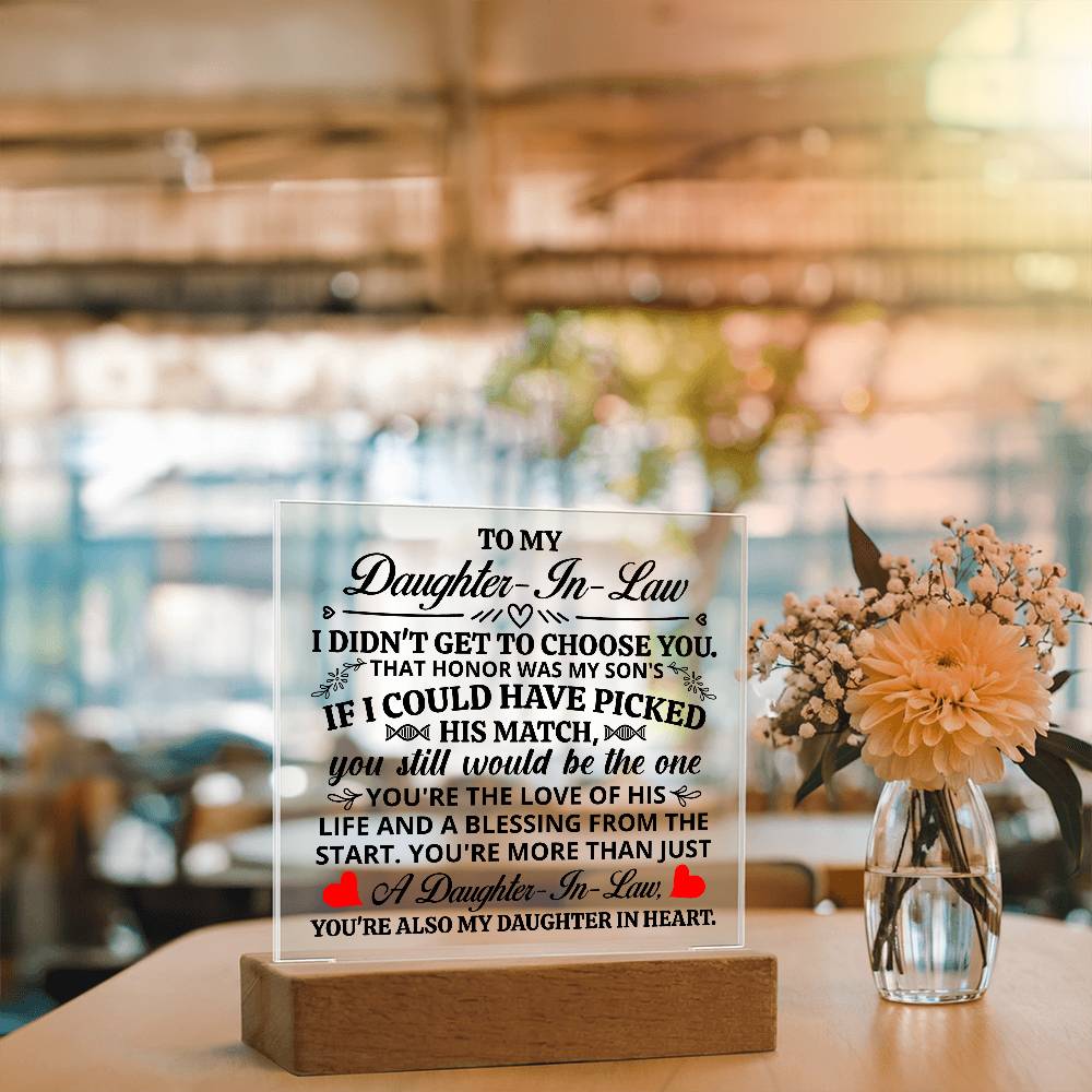 Acrylic plaque for daughter-in-law featuring heartfelt message displayed on wooden base in a cozy interior setting.