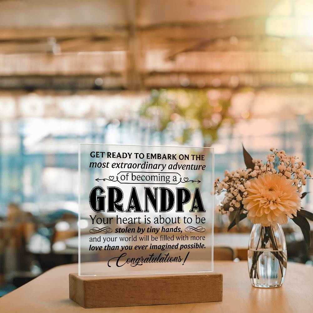 Acrylic square plaque featuring a heartfelt message about becoming a grandpa, displayed on a wooden base.