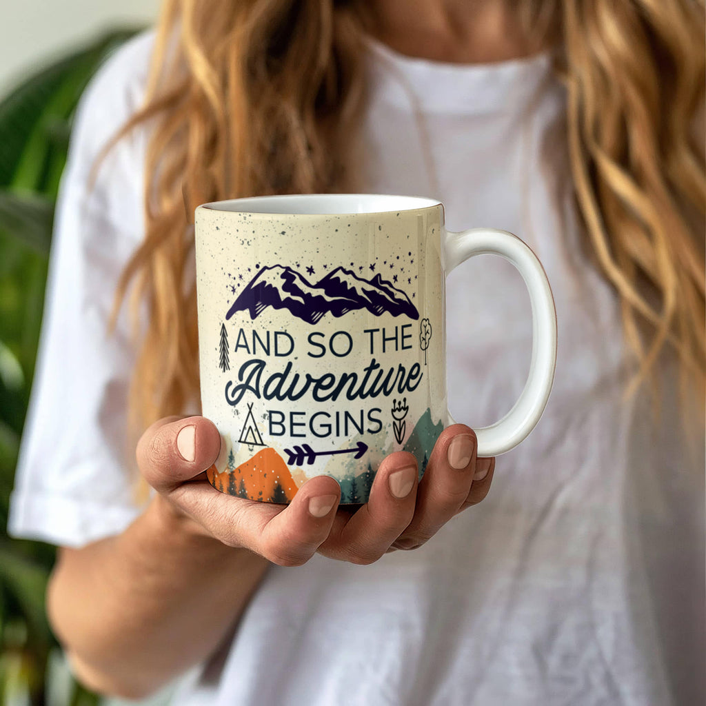 custom ceramic coffee mug featuring a mountains and adventure design held by a person in a white shirt