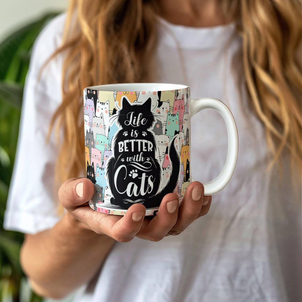Life Is Better With Cats – Ceramic Mug held by a person against a soft background, showcasing its unique design.